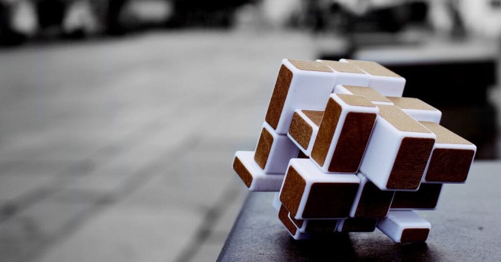 Artistic cube puzzle placed on a surface in an urban setting, capturing depth and focus.