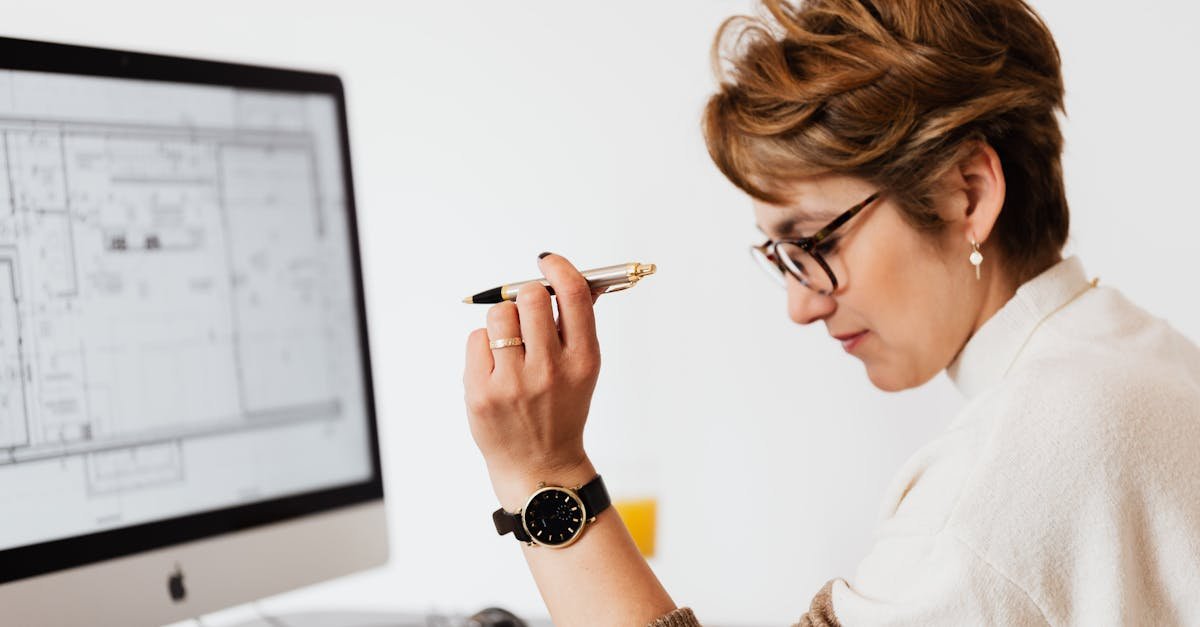 Confident businesswoman using computer for architectural analysis in a modern office.