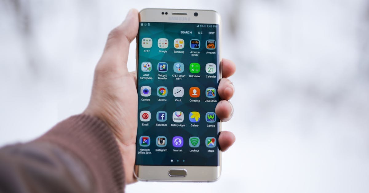 Close-up of a hand holding a Samsung smartphone displaying various app icons, emphasizing technology and connectivity.