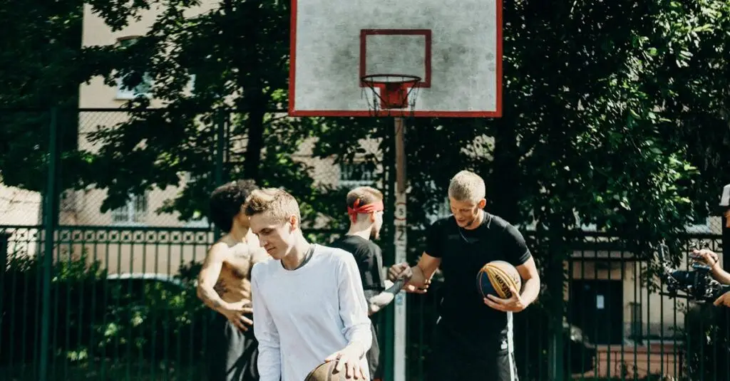 Group of adults playing basketball on an outdoor court during the day.