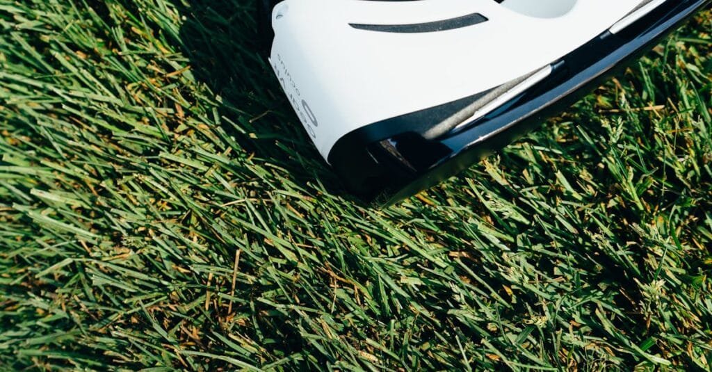 A close-up shot of VR goggles placed on a green grass lawn under sunlight.