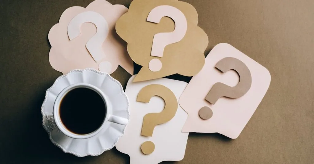 Creative concept with coffee cup and paper question marks on a table.