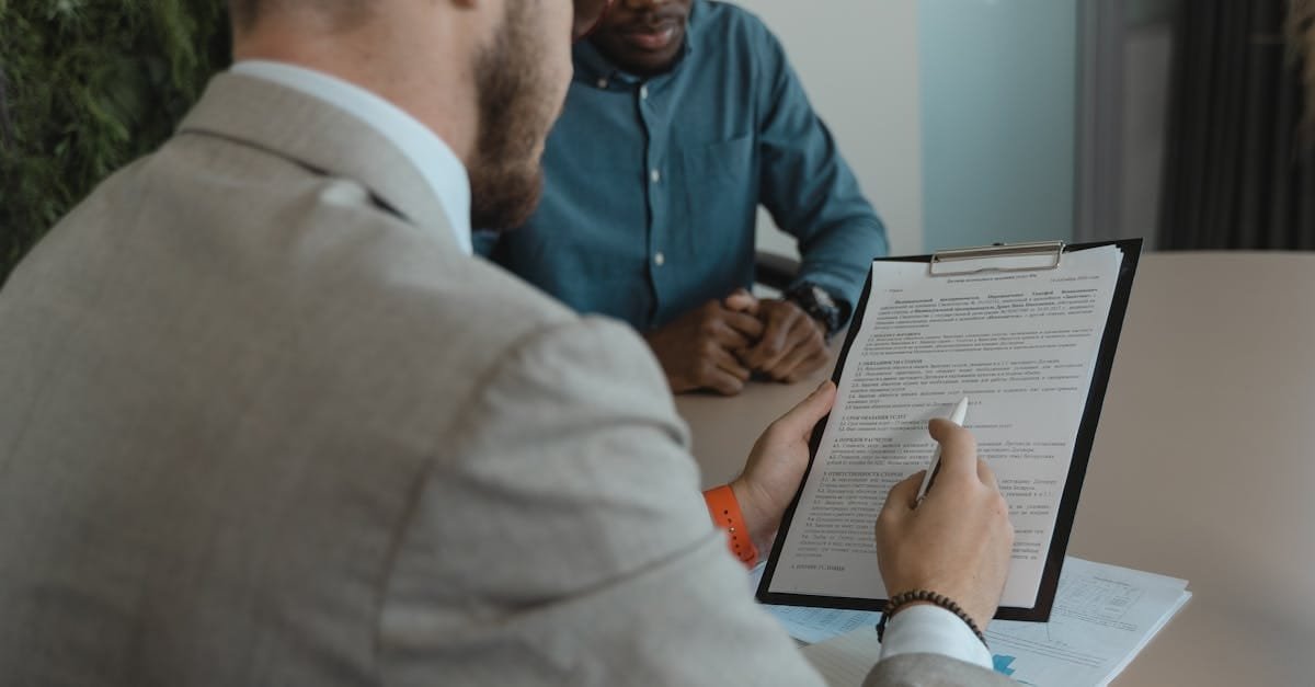 A recruiter reviews a candidate's documents during a job interview in a modern office setting.