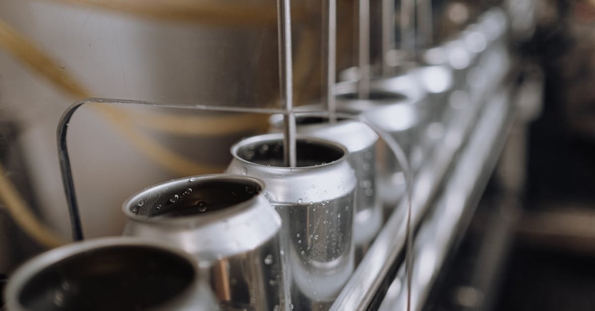 Detailed view of an industrial canning process with aluminum cans on an automatic assembly line.