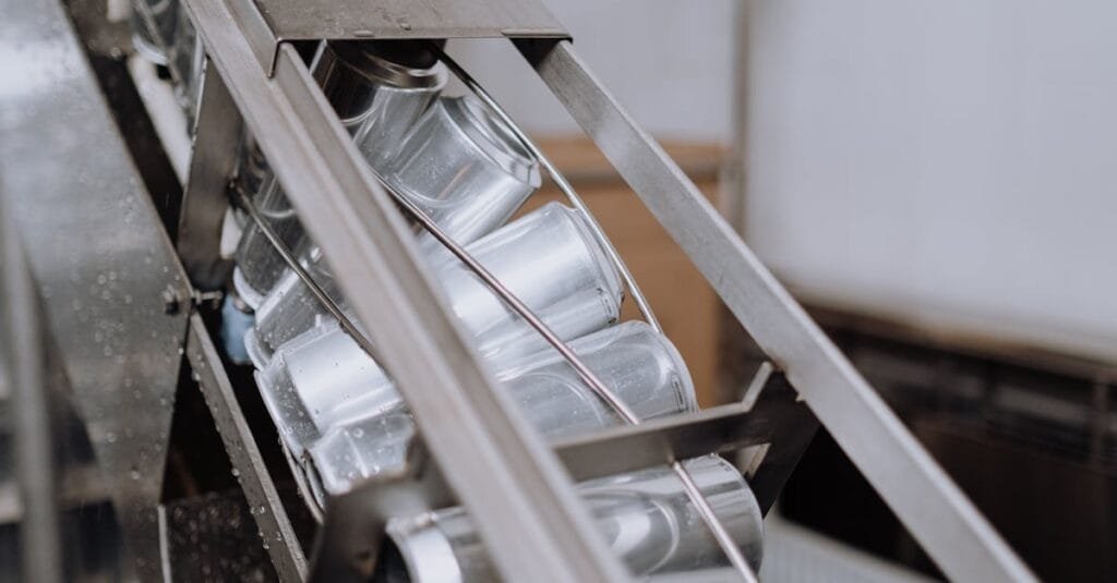 Close-up of automated canning equipment in a brewery showcasing production efficiency.
