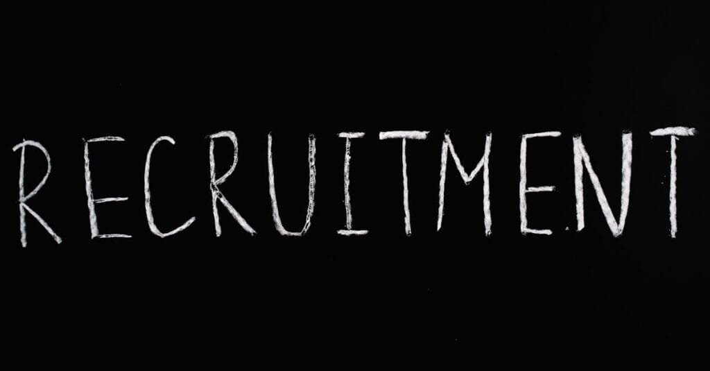 Chalk-written 'RECRUITMENT' on a black chalkboard, ideal for HR and hiring themes.