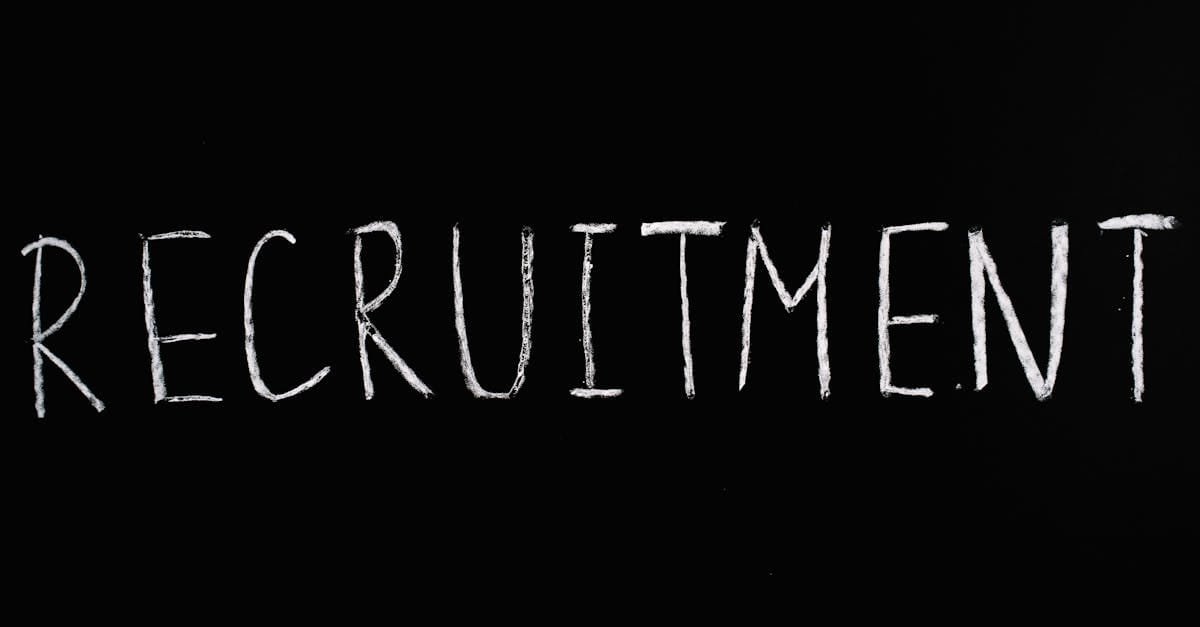 Chalk-written 'RECRUITMENT' on a black chalkboard, ideal for HR and hiring themes.