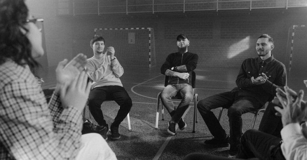 A black and white image of a support group engaged in a therapy session.