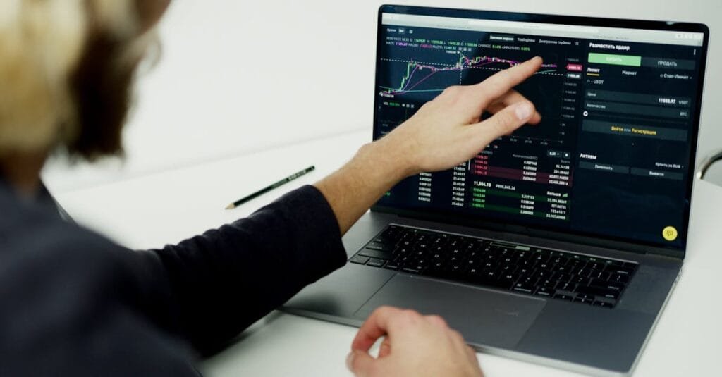 A person analyzing stock market graphs on a laptop screen, showcasing trading insights.
