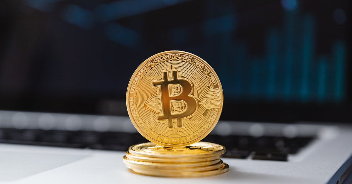 A shiny gold Bitcoin coin on laptop keyboard, symbolizing digital currency and blockchain technology.