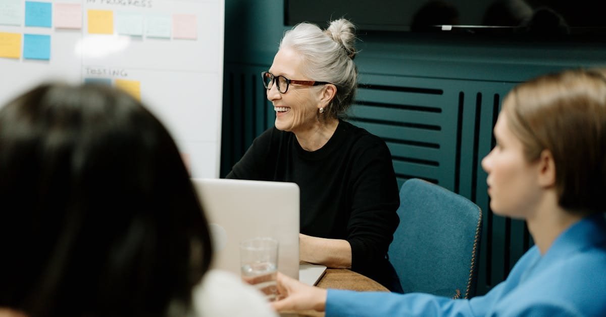Smiling senior businesswoman leading a diverse team meeting in an office.