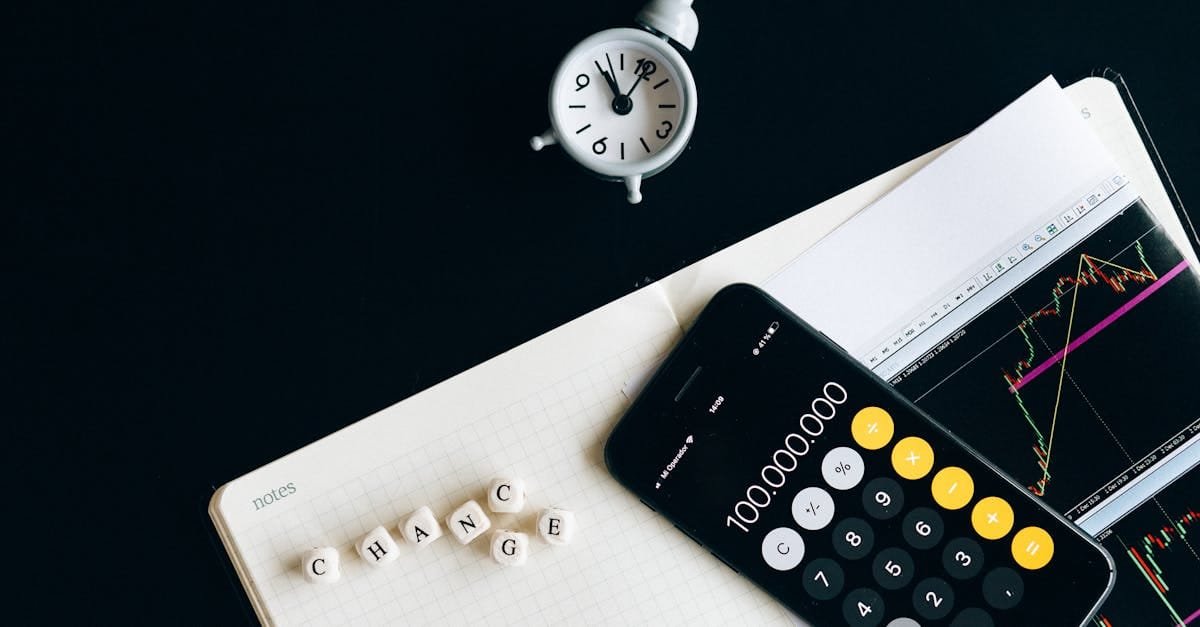 Notebook with an iPhone displaying 100,000,000, desk clock and financial charts suggesting market analysis.