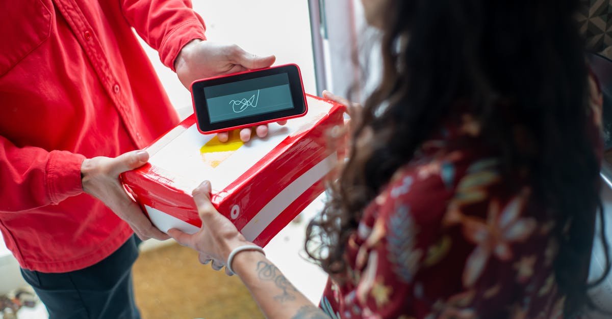 A delivery person hands over a package to a recipient using an electronic device for signature confirmation.