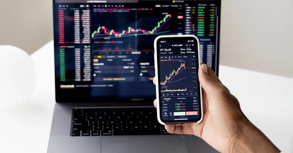 Person checking stock market graphs on laptop and smartphone, focusing on financial data.