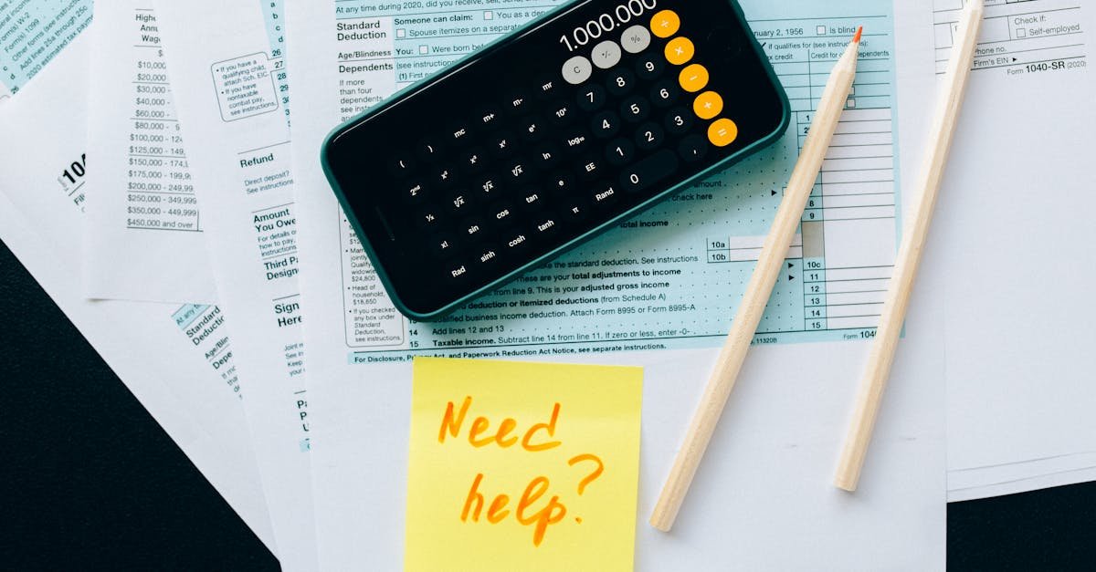 Top view of financial papers with a calculator, pencils, and a note saying 'Need help?' indicating tax or accounting assistance.