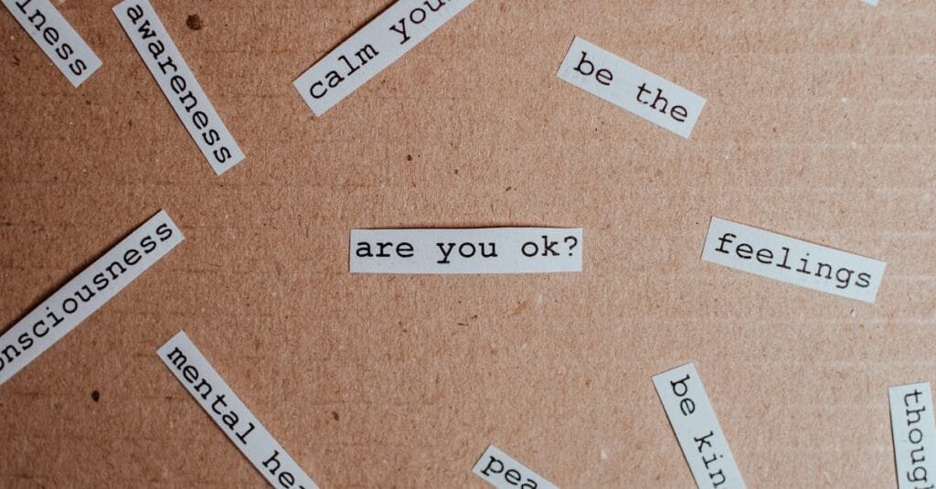 Cut-out words promoting mental health awareness on cardboard background.