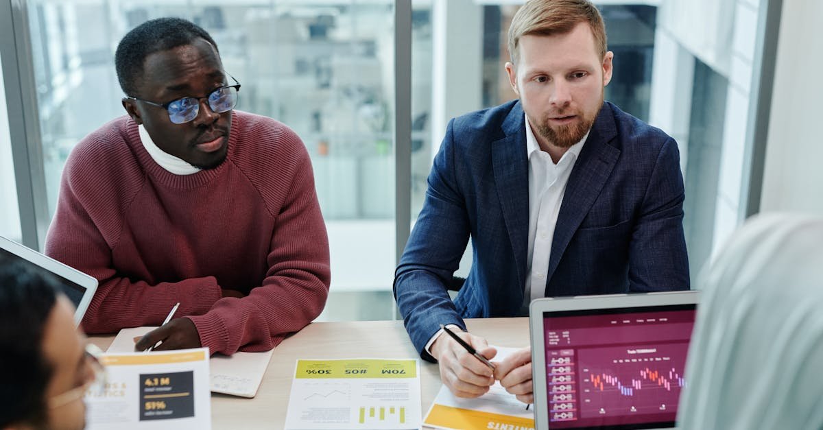 Multicultural team discussing financial data and graphs in a modern office setting.