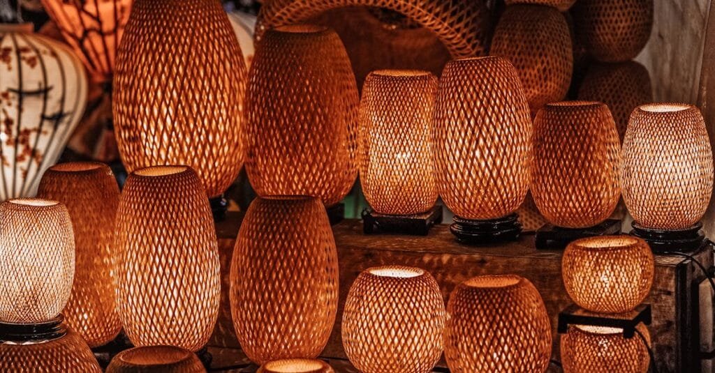 A collection of handmade woven lamps with warm glow indoors, showcasing traditional craftsmanship.