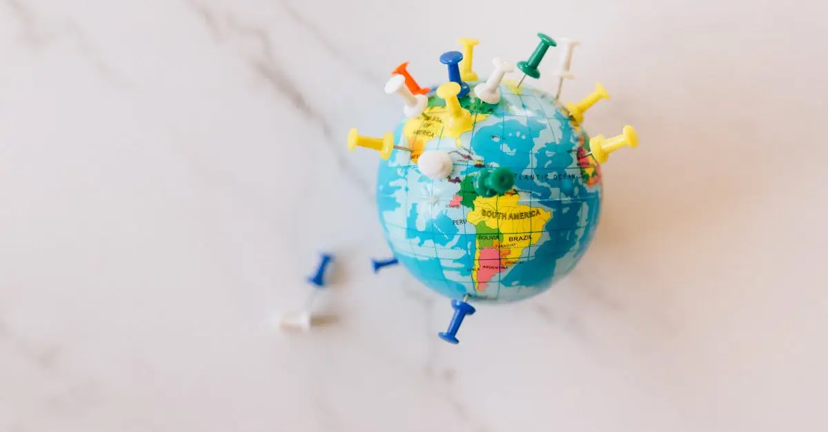 A globe decorated with colorful push pins on a marble surface represents global connections