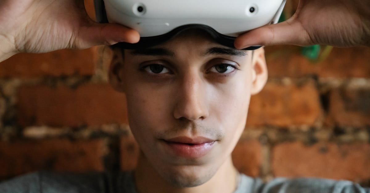 Close-up of a man wearing a VR headset indoors with a brick wall background.