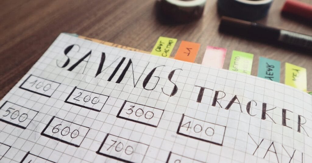 Close-up of a handmade savings tracker with colored tabs on a wooden table, ideal for financial planning visuals.