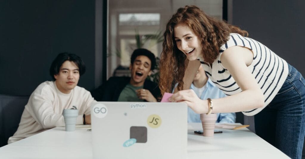 A diverse group of young professionals collaborating enthusiastically in an office setting.
