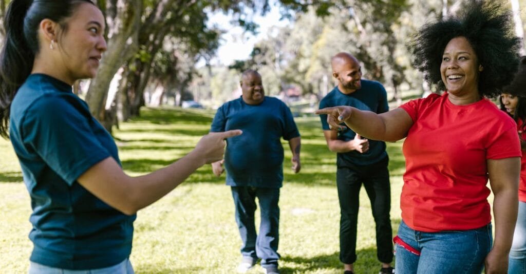 Group of diverse adults enjoying a team building exercise in a sunny park.