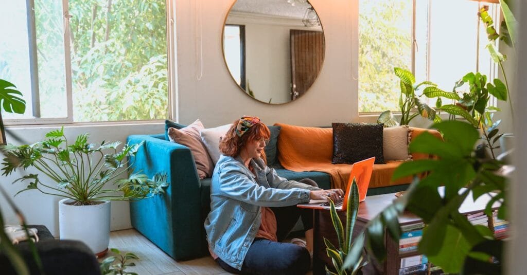 Woman working remotely from a cozy living room surrounded by plants.