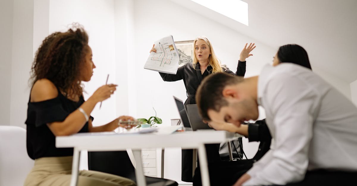 Team experiencing stress during a heated office meeting. Diverse colleagues engage in emotional discussion indoors.