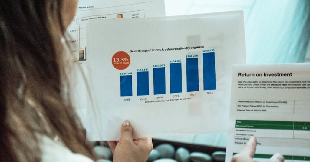 Person analyzing financial graphs and ROI reports, focusing on investment growth.