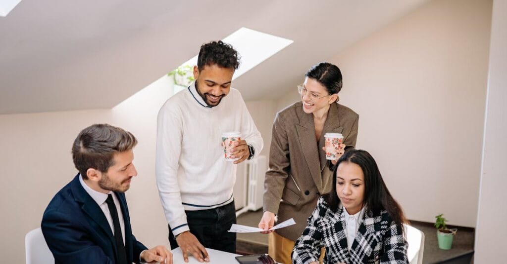 Group of diverse colleagues collaborating and discussing business ideas in a modern office setting.