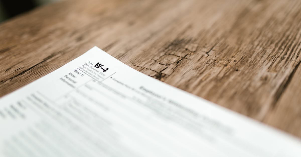 Close-up of a W-4 form resting on a rustic wooden table, highlighting textures.