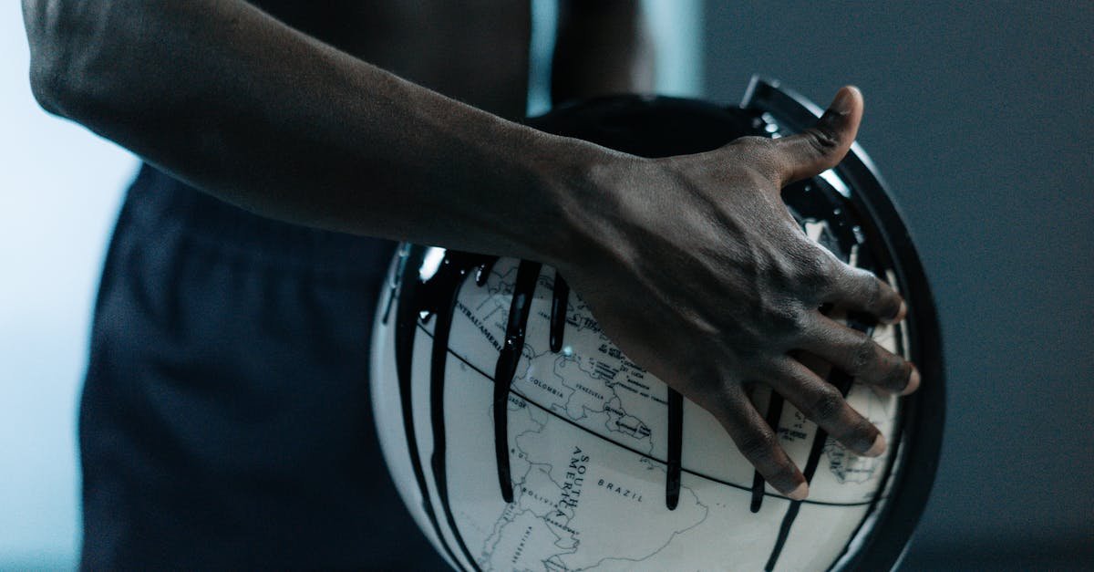 A hand holding a globe dripping with oil, symbolizing pollution and fossil fuels.