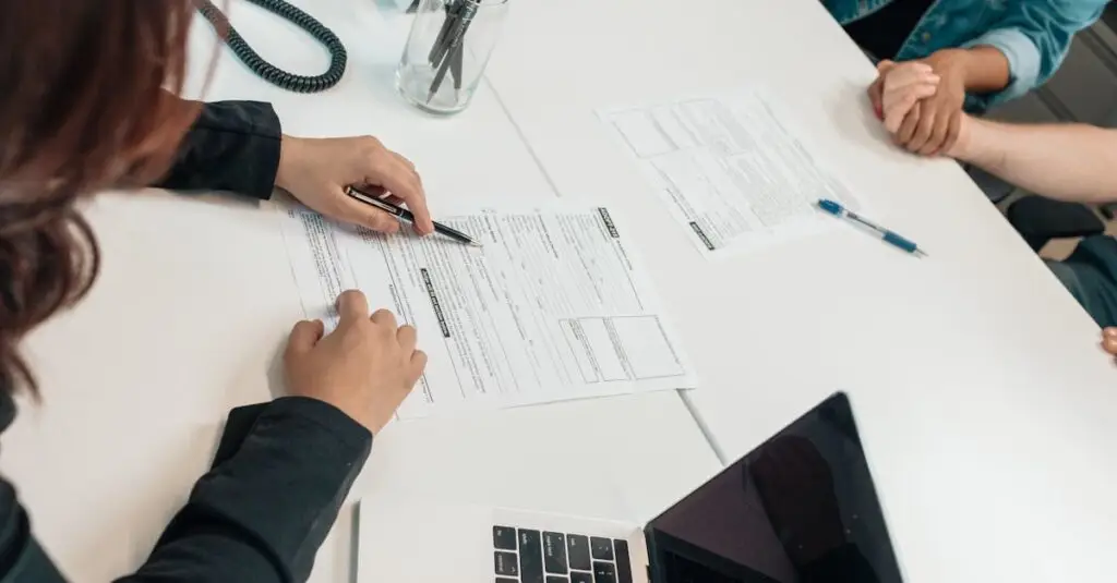 A professional meeting with document signing at an office desk, focusing on teamwork.