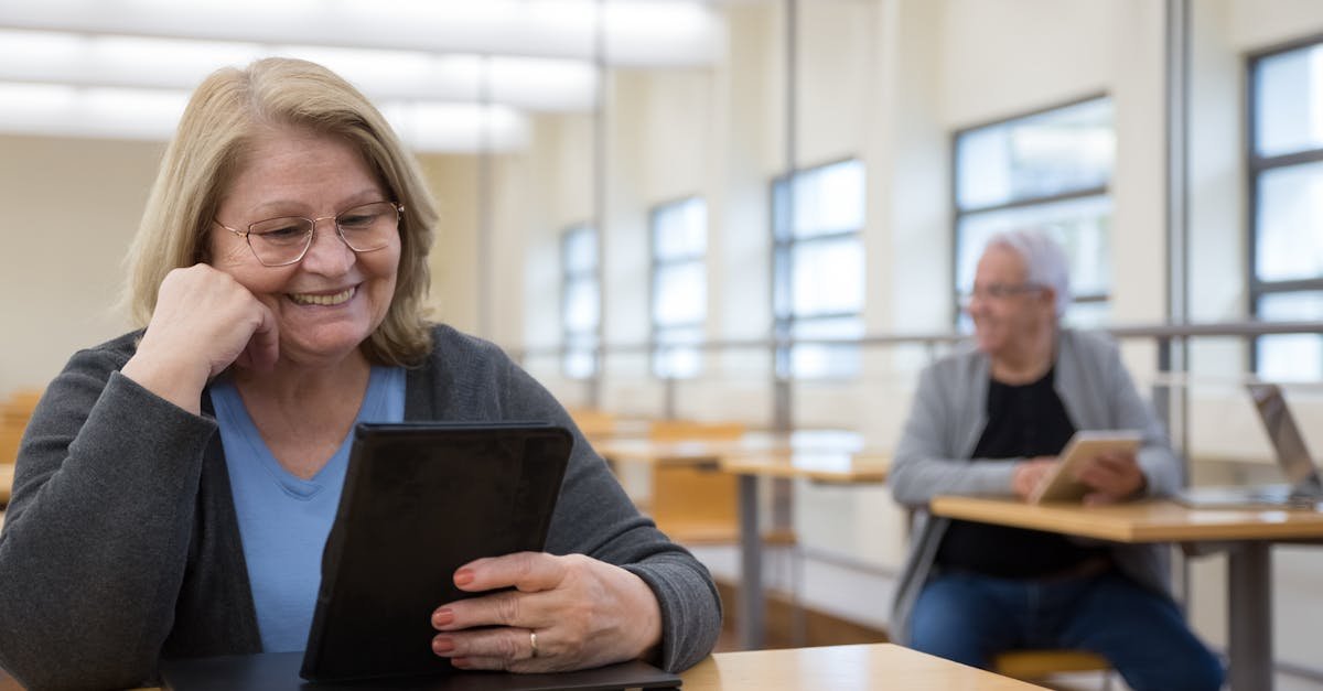 Senior adults learning to use tablets at a modern classroom in Portugal.