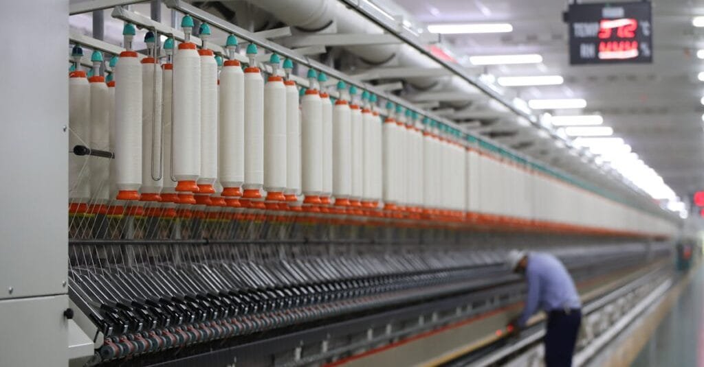 A textile factory in India showcasing modern spinning machinery with a worker.