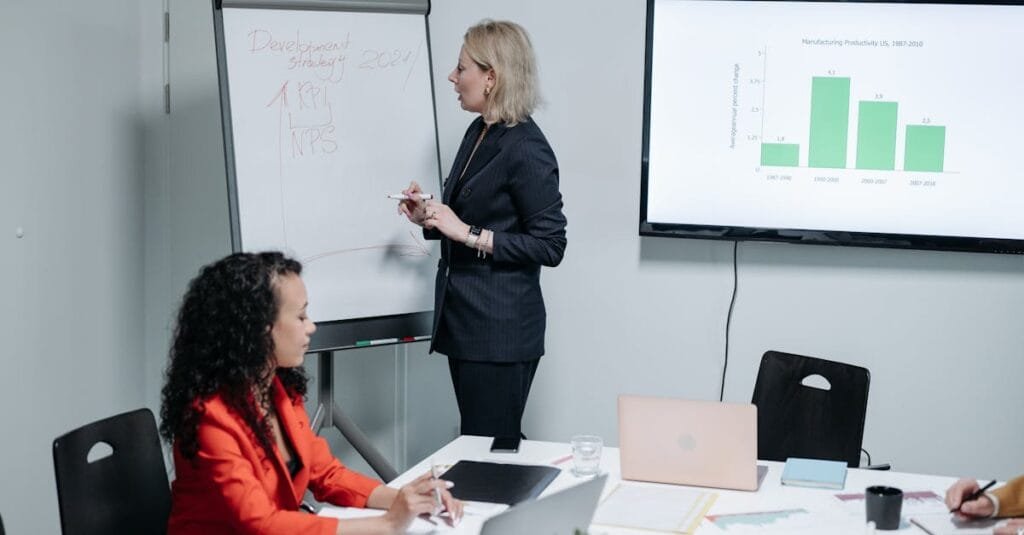 Businesswomen discussing strategy in modern meeting room with charts and analysis.