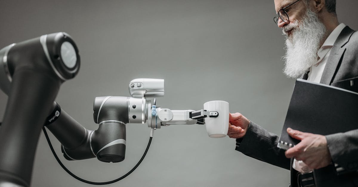 An elderly man receives a cup from a robotic arm in a modern office setting.