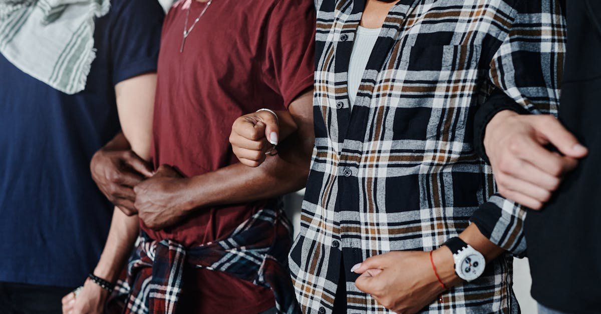 Close-up of a diverse group of adults linking arms, symbolizing unity and solidarity.
