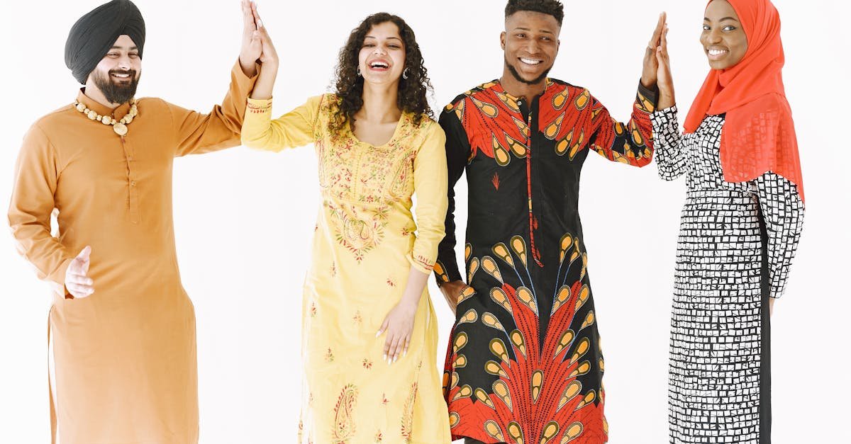 A joyful group of adults from diverse backgrounds high-fiving in traditional clothing.