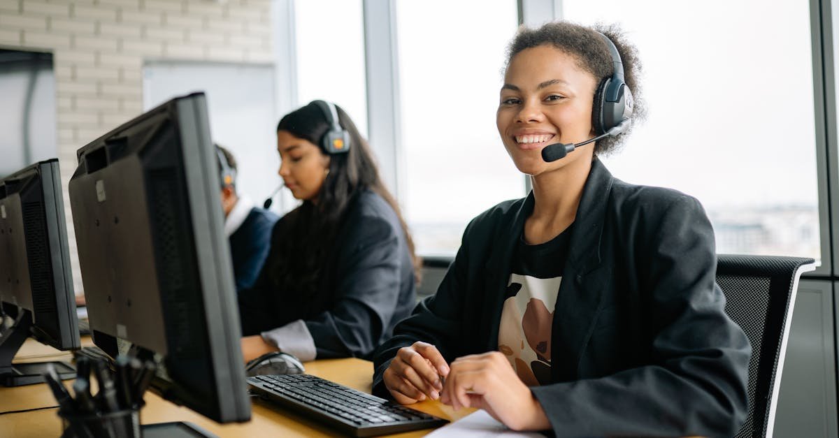 Smiling customer service representatives with headsets working in a bright modern office.