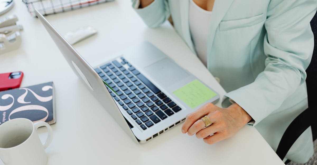 Businesswoman in office attire working on a laptop at a desk, symbolizing modern professional life.