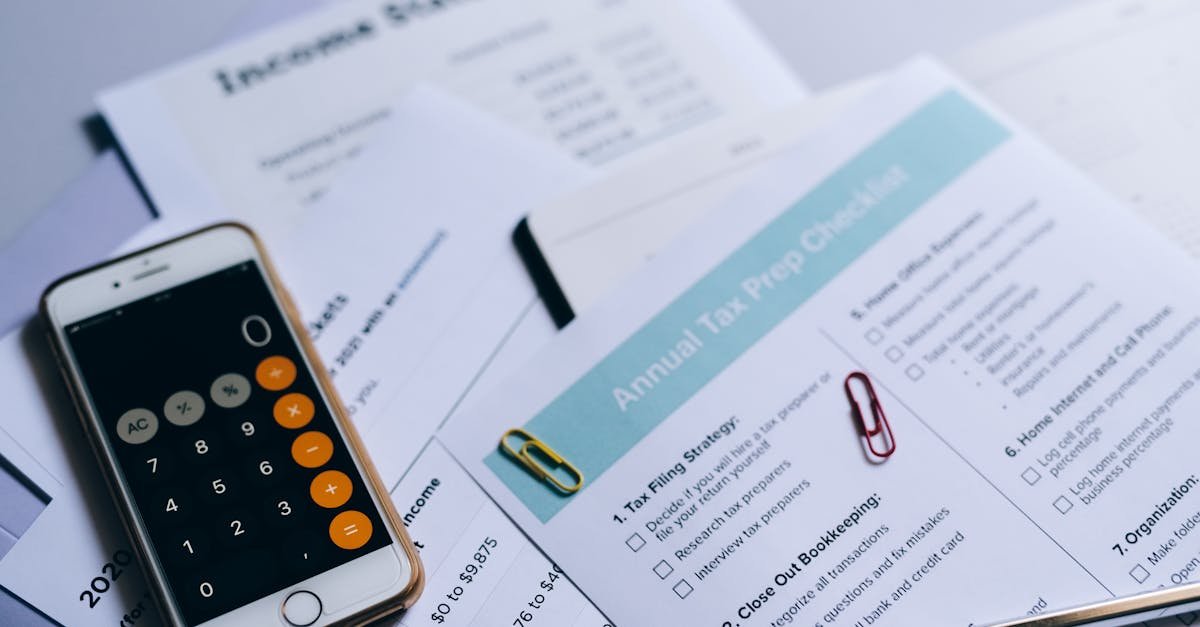 Tax preparation setup with documents, smartphone calculator, and checklist.