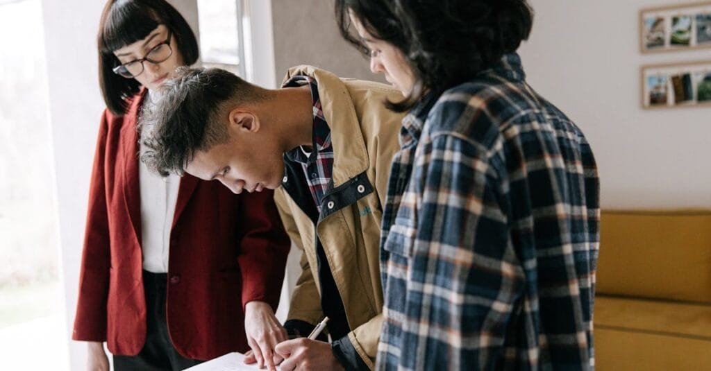 Young couple signing a real estate agreement with an agent indoors.