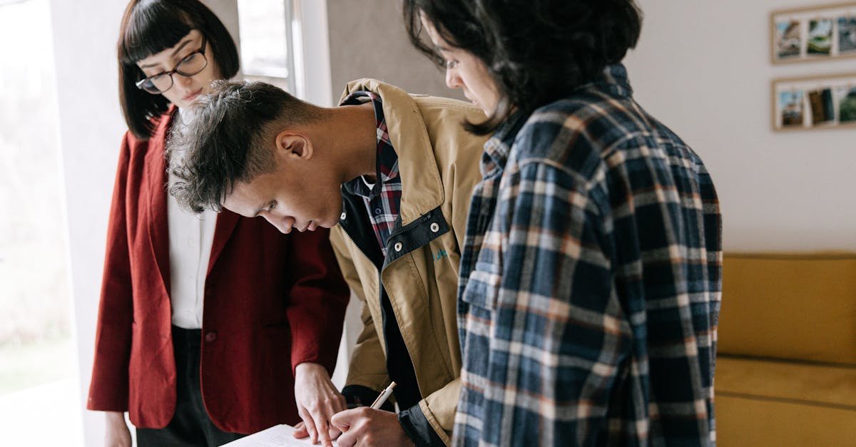 Young couple signing a real estate agreement with an agent indoors.