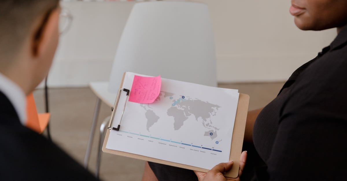 Professional discussion with world map and data visualization on a clipboard.