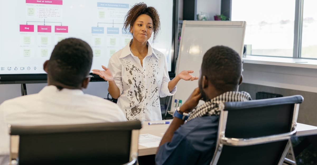 A woman leads a team meeting in a modern office using digital presentations.