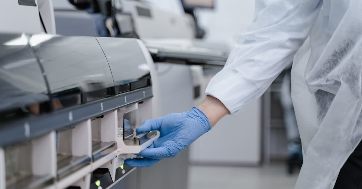 Lab technician in a white coat using equipment with precision in a sterile environment.