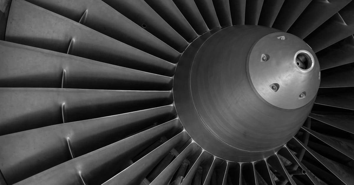 Detailed black and white image of an airplane turbine engine showcasing blades and craftsmanship.