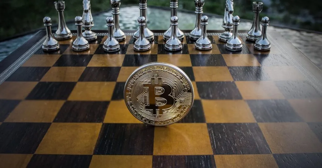 Bitcoin coin standing on a chessboard with silver and brass chess pieces. Concept of strategic digital currency investment.